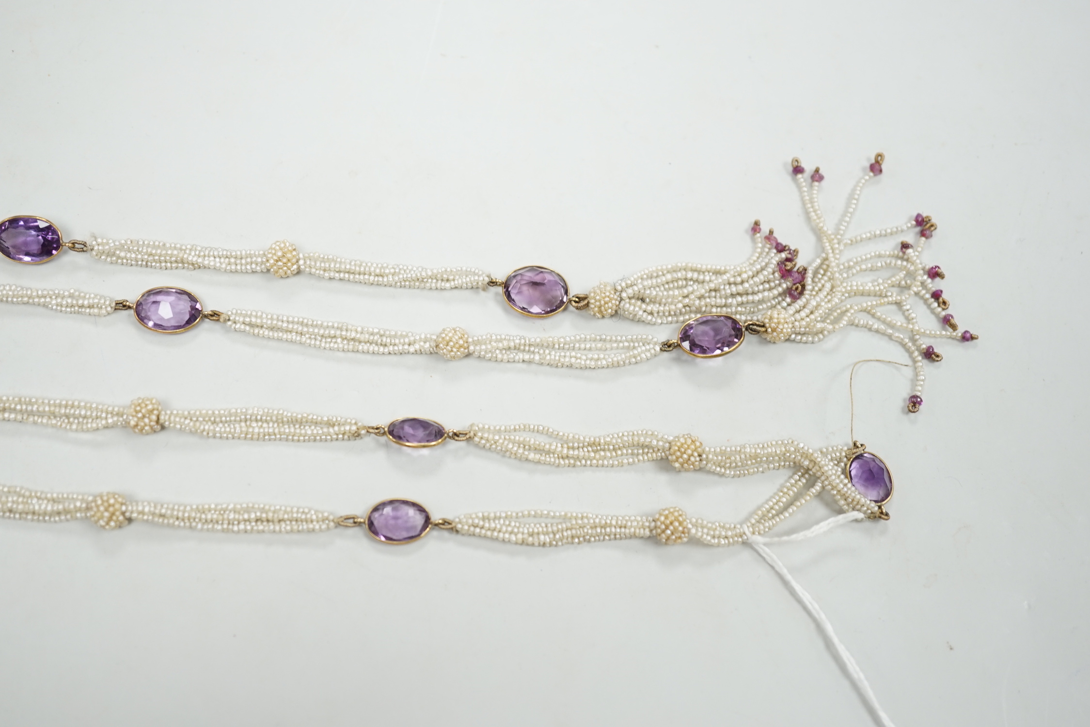 A 19th century Indian multi strand seed pearl and oval cut amethyst set long necklace, with gem set tassel terminals, 170cm.